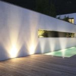 Terrasse en bois autour d'une piscine avec lumière